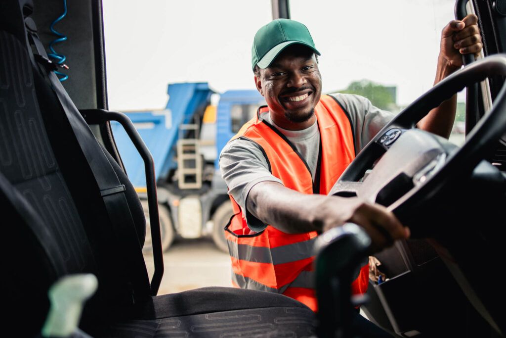 A fleet driver happily climbs into the driver’s seat of his truck.