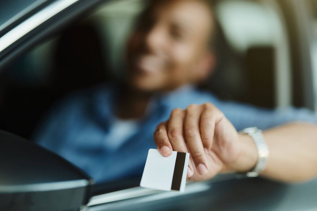 A driver of a fleet pays for fuel at a gas station with his fleet fuel card.