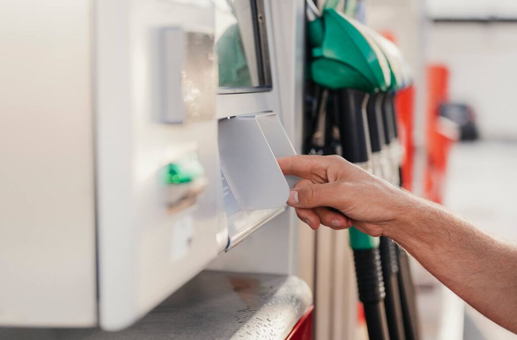 A fleet driver pays for gas with a fuel card at a gas station.