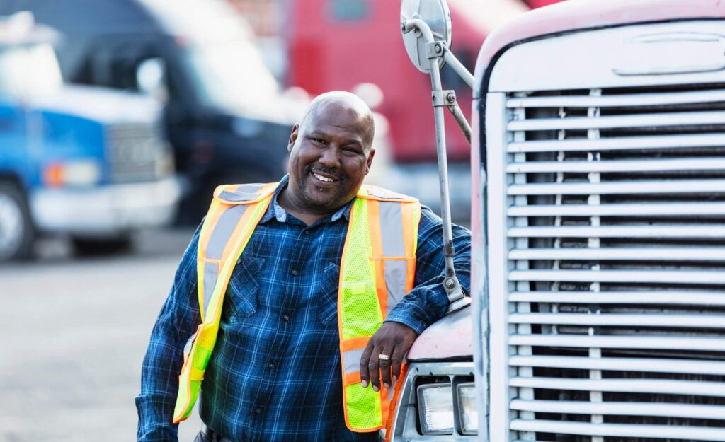 A fleet driver stands outside his rig.