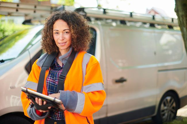 A fleet manager of delivery vans reviews fuel card data on her tablet in real-time.