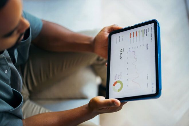 A small business owner looks at charts and analytics from his laptop about fleet fuel cards.