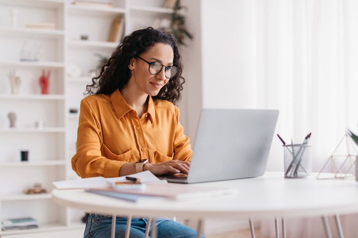 A business owner reviews the data about fleet fuel cards on her laptop at her desk.