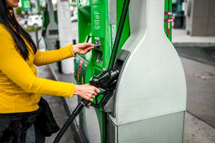 A fleet driver pays for gas at the pump with a fuel card.